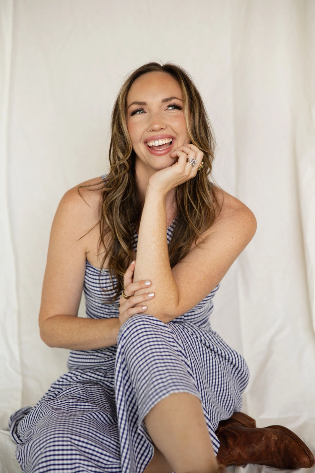 Kalie Bennett, laughing, seated against a white backdrop